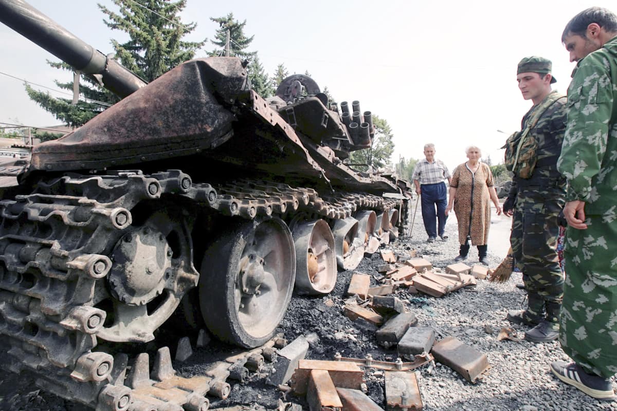 Etelä-Ossetian asukkaat tutkivat tankkia Tskhinvalissa.