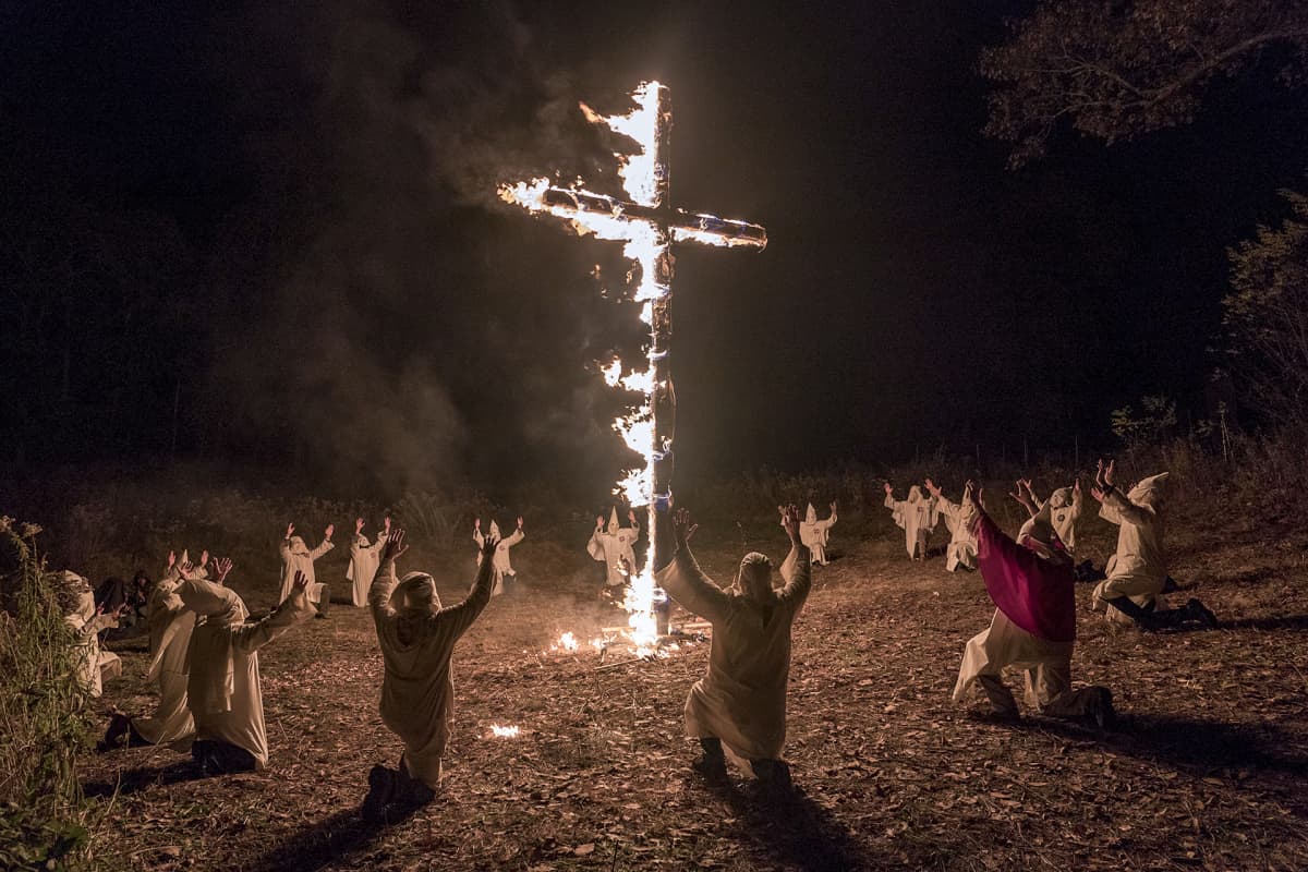 palava risti ja huppupäisiä miehiä