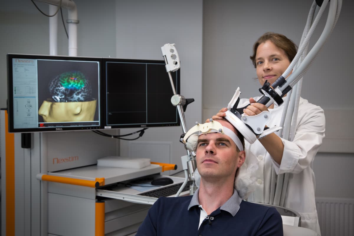 Kliinisen neurofysiologian erikoislääkäri Selja Vaalto esittelee yhdessä Aalto-yliopiston tutkija Jaakko Niemisen kanssa TMS laitetta.