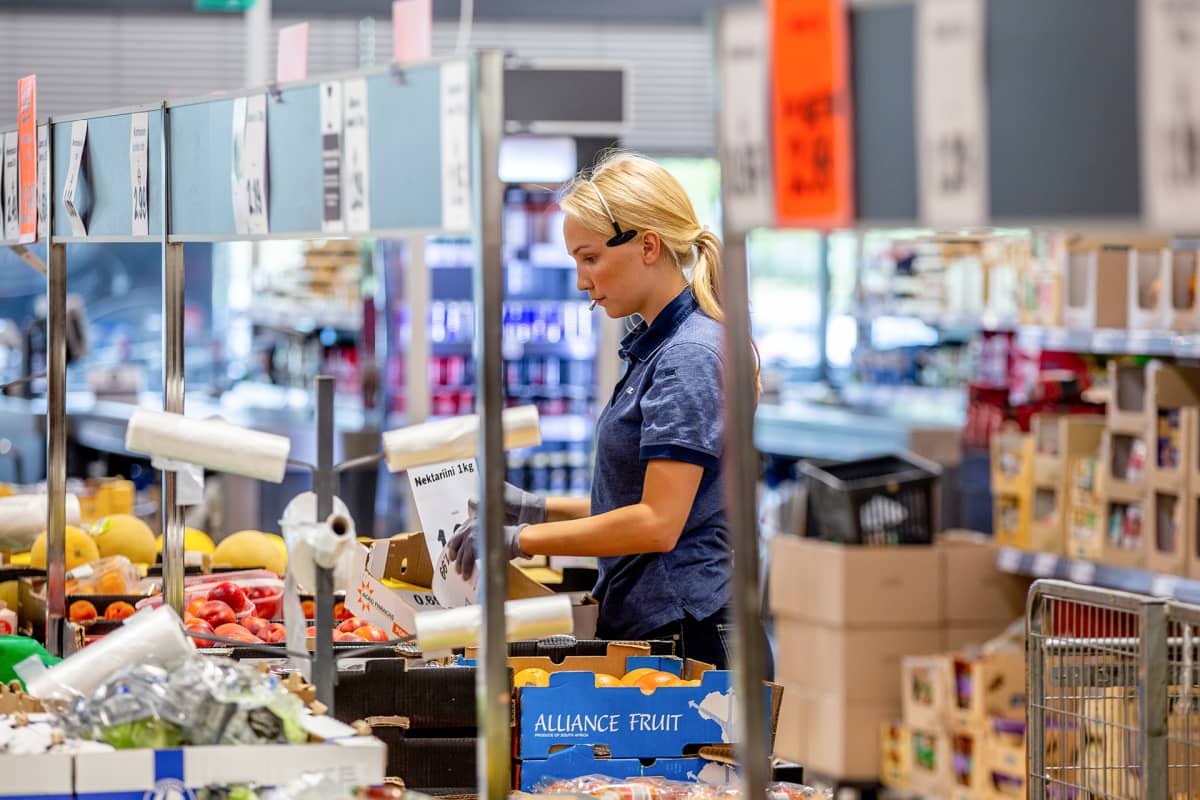 Eeva Repo täyttää hedelmävalikoimaa kaupassa.