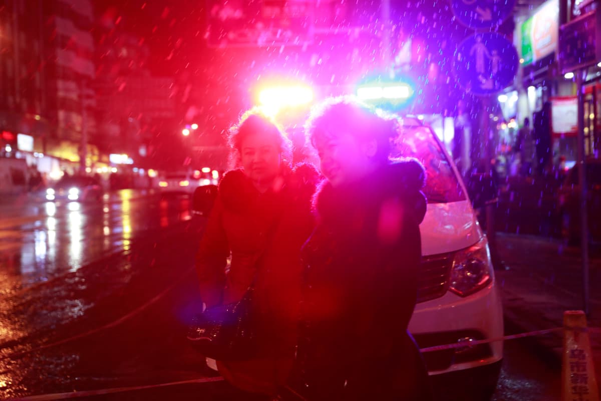 Uiguurinainen käveli poliisiauton edestä Urumqin kaupungissa Xinjiangissa.
