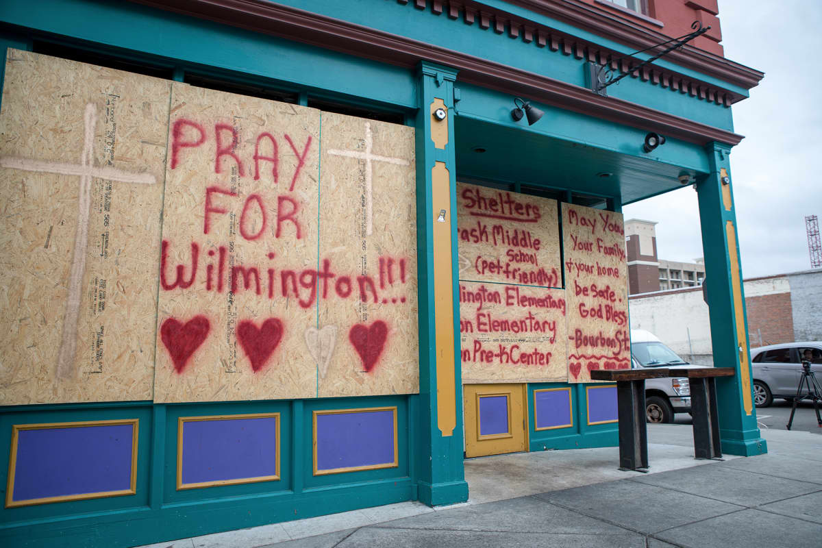 "Pray for Wilmington", lukee suojatussa kaupan ikkunassa.