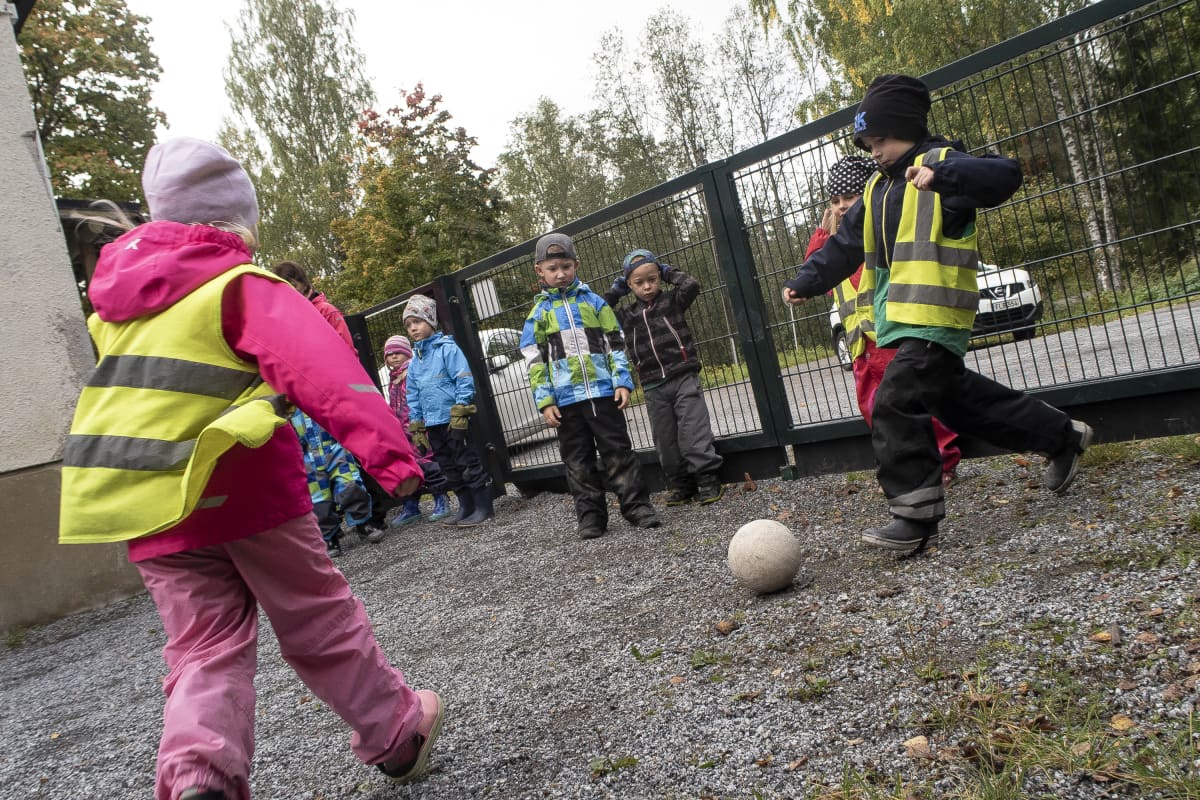 Eskarilaisia pelaamassa jalkapalloa päiväkodin pihalla Nokialla.