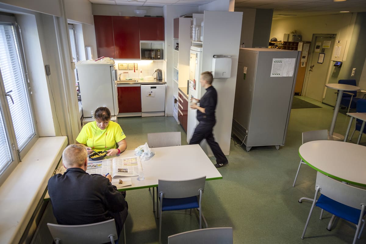 kolme työntekijää tauolla keittiössä