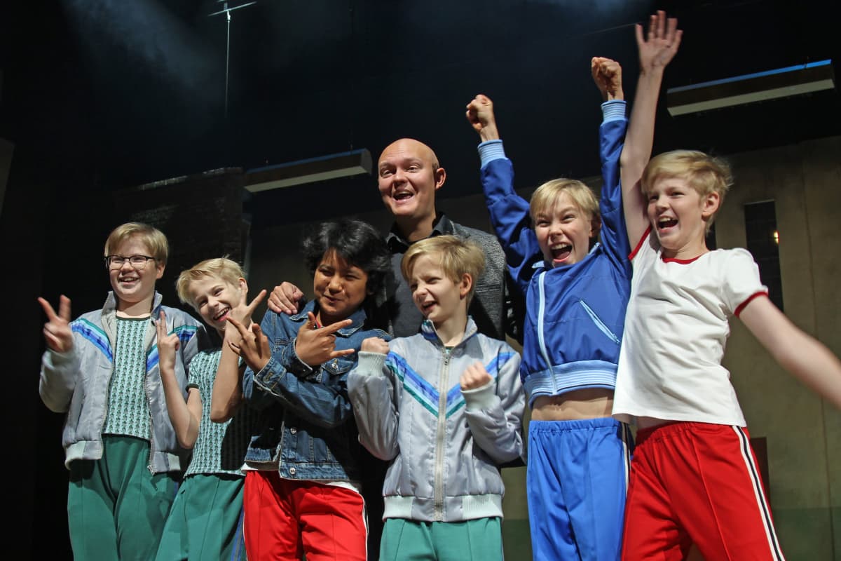 Billy Elliot -musikaalin pääosien esittäjät poseeraavat lavalla ohjaaja Samuel Harjanteen kanssa