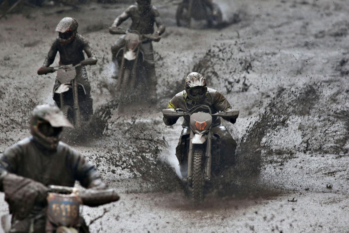 Joukko endurokuskeja ajaa mustanharmaassa mutavellissä Gotlannin saarella.