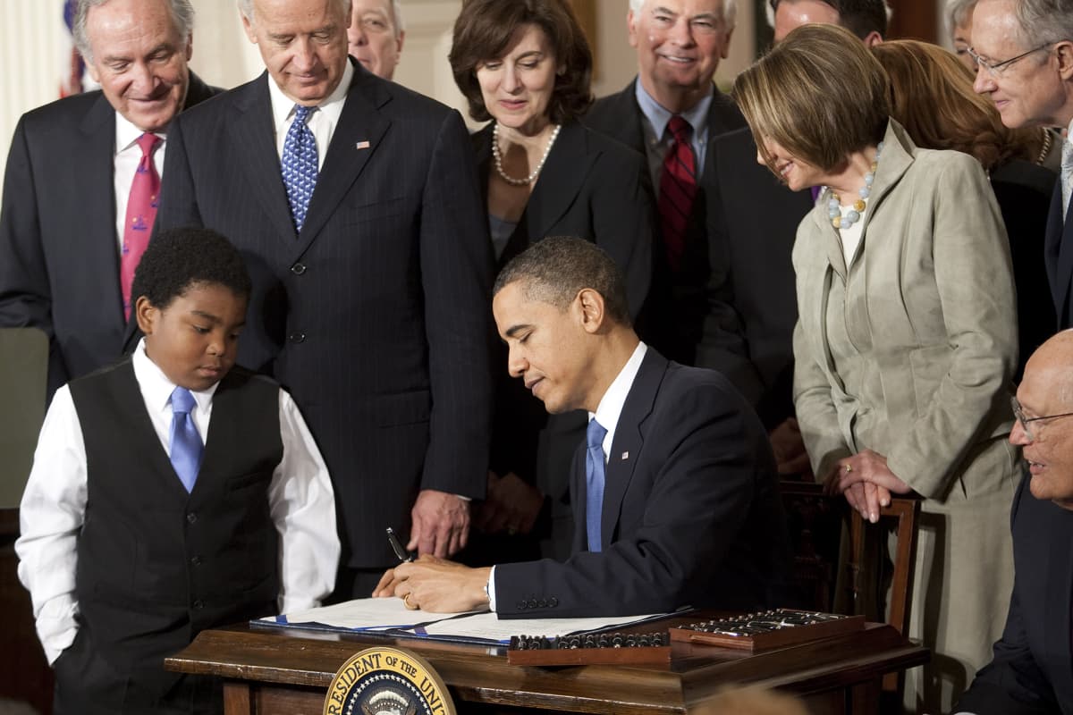 Kuvassa presidentti Barack Obama allekirjoittaa lakipaperia terveydenhuoltouudistuksesta.