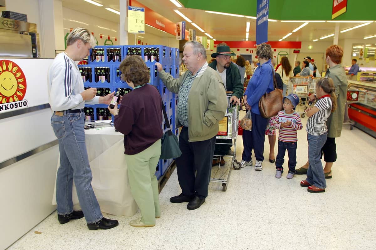 Matti Nykänen elintarvikeliikkeessä esittelemässä nimikkosiideriään (Matti-siideri) ja
kirjoittamassa nimikirjoituksia vuonna 2002.