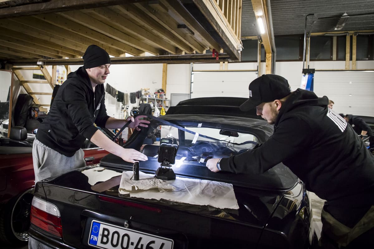 Miehet korjaavat autoa.