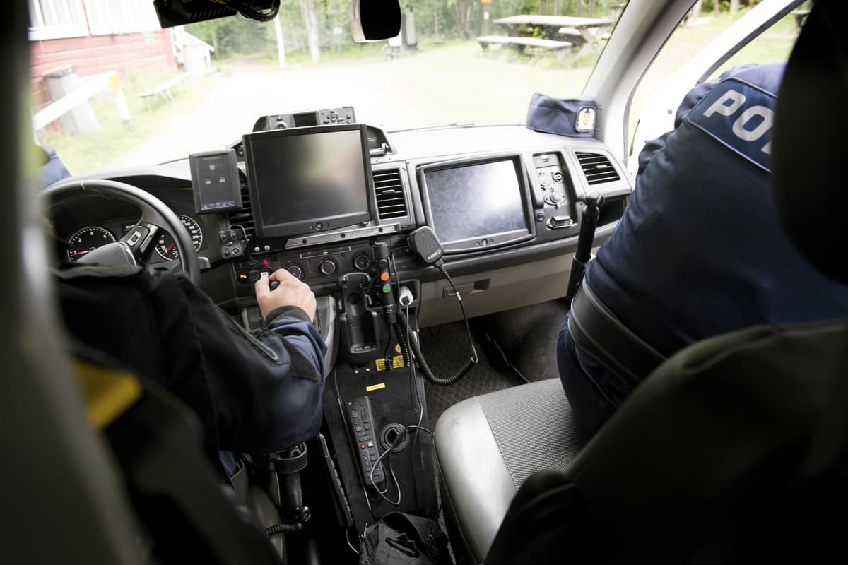 Poliiseja poliisiautossa.