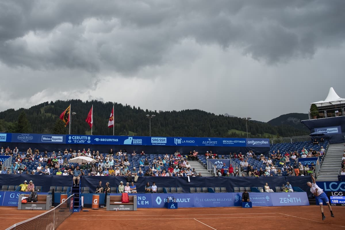 Tummia pilviä tenniskatsomon yllä.