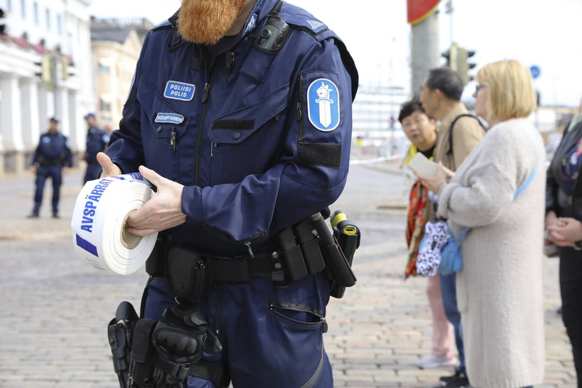 Poliisi laittamassa poliisinauhaa Venäjän presidentti Vladimir Putinin Suomen vierailun reitin varrella kauppatorilla Helsingissä 21. elokuuta.