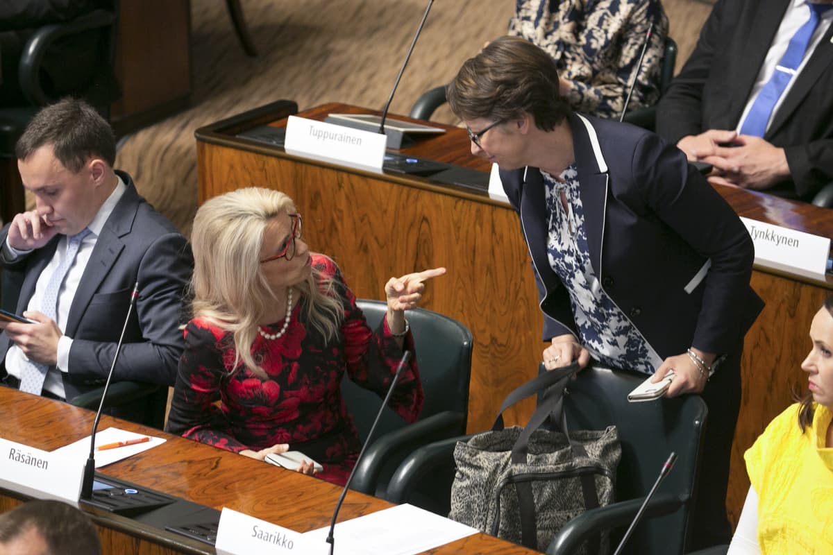 Päivi Räsänen ja Sari Essayah keskustelevat eduskunnan täysistunnossa.