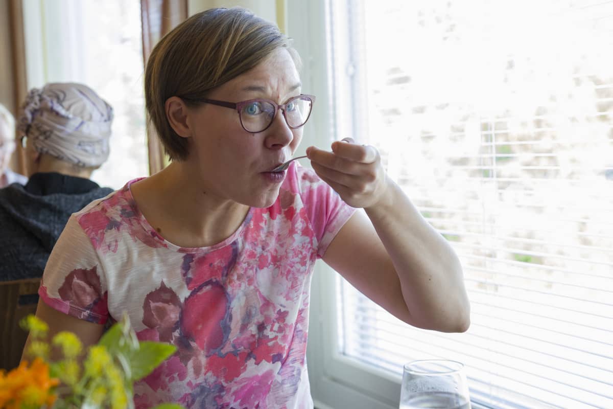 Hannele Kelavuori maistelee villiyrttisalaattia.