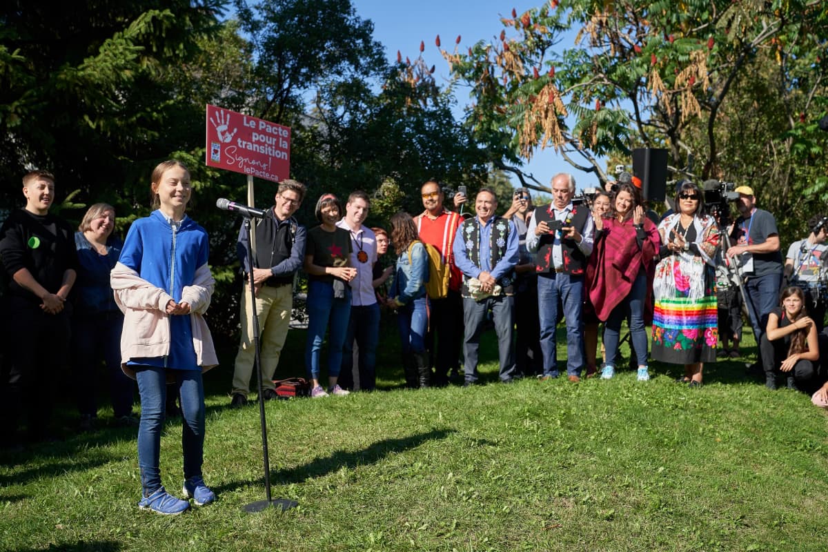 Greta Thunberg taustallaan suuri joukko ihmisiä.