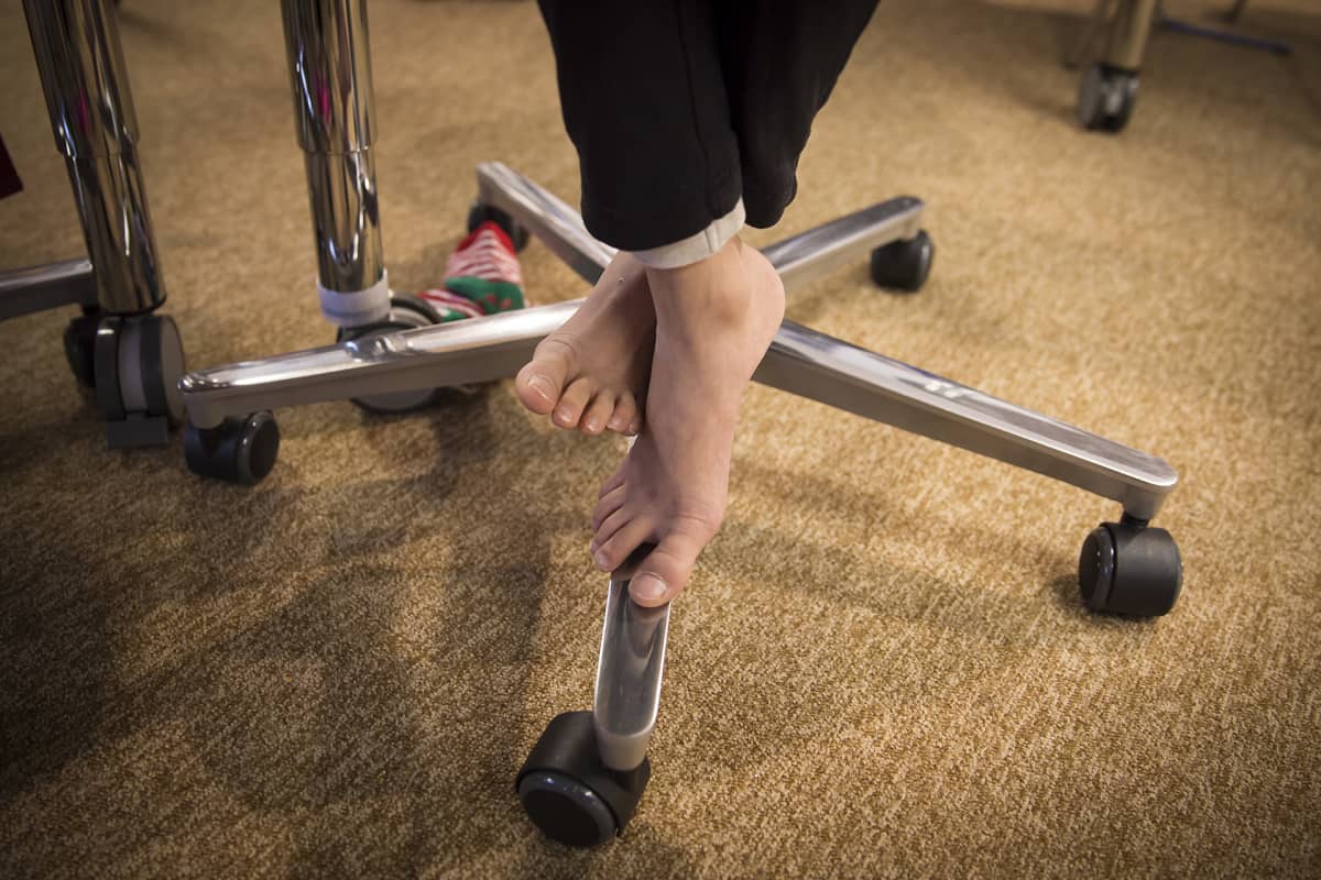Oppilaan paljaat varpaat luokkahuoneessa.