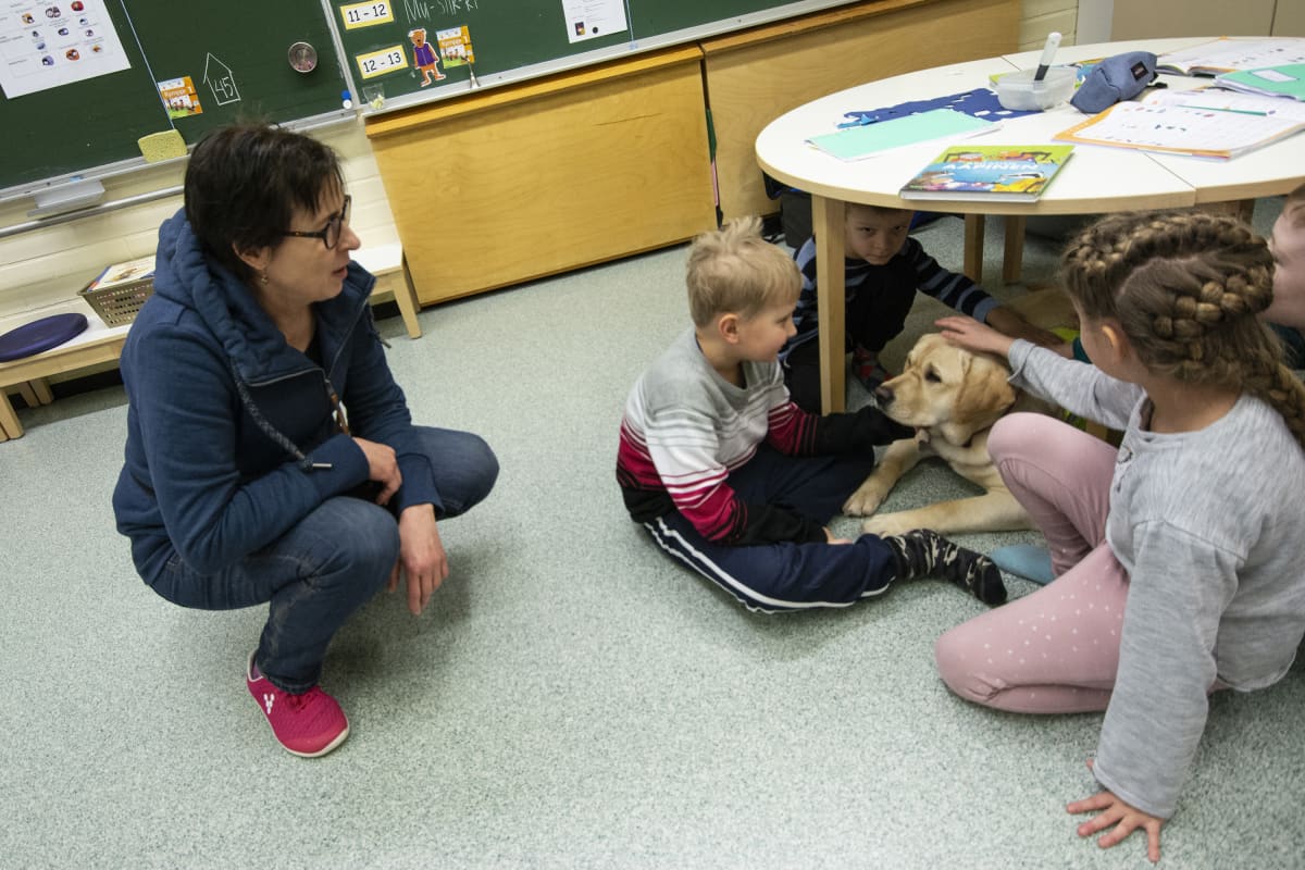 Ruuti-koira yhdessä oppilaiden kanssa.