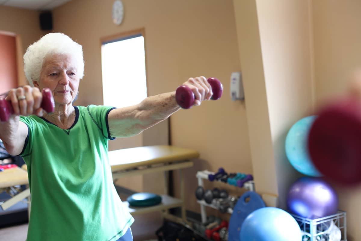 Seniori nainen kuntosallilla.