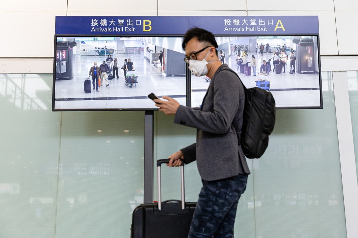 Hongkongiin saapuvalla matkustajalla hengityssuojain naamalla.