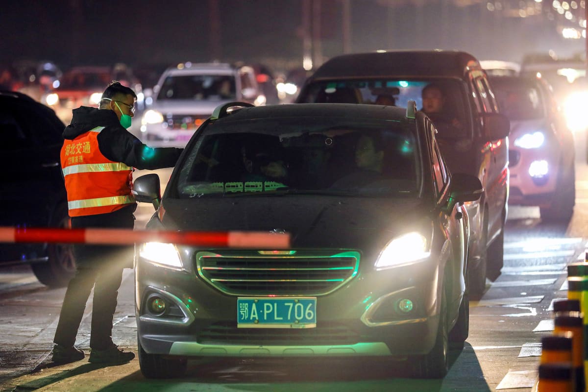 Autoilijoiden ruumiinlämpöä mitataan moottoritiellä Wuhanissa 21. tammikuuta.