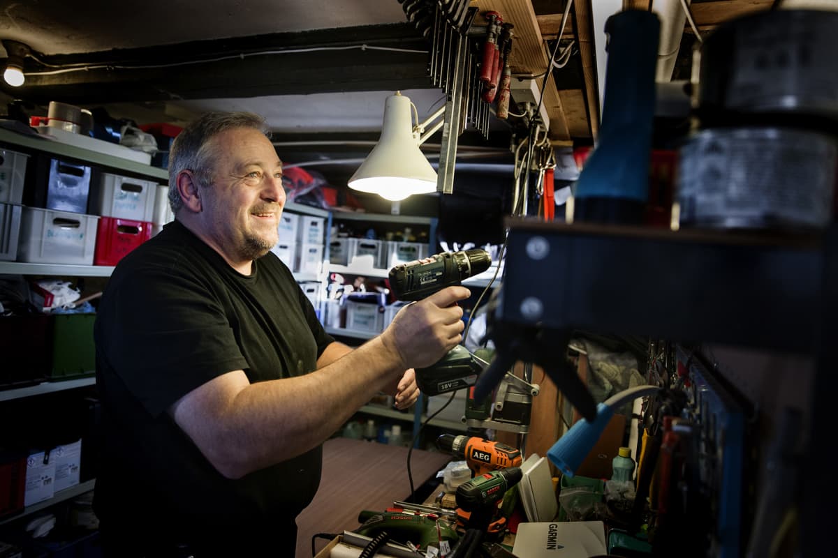 Claus Rolsted korjaa purjeveneensä navigaattoria kotinsa nikkarointitilassa.
