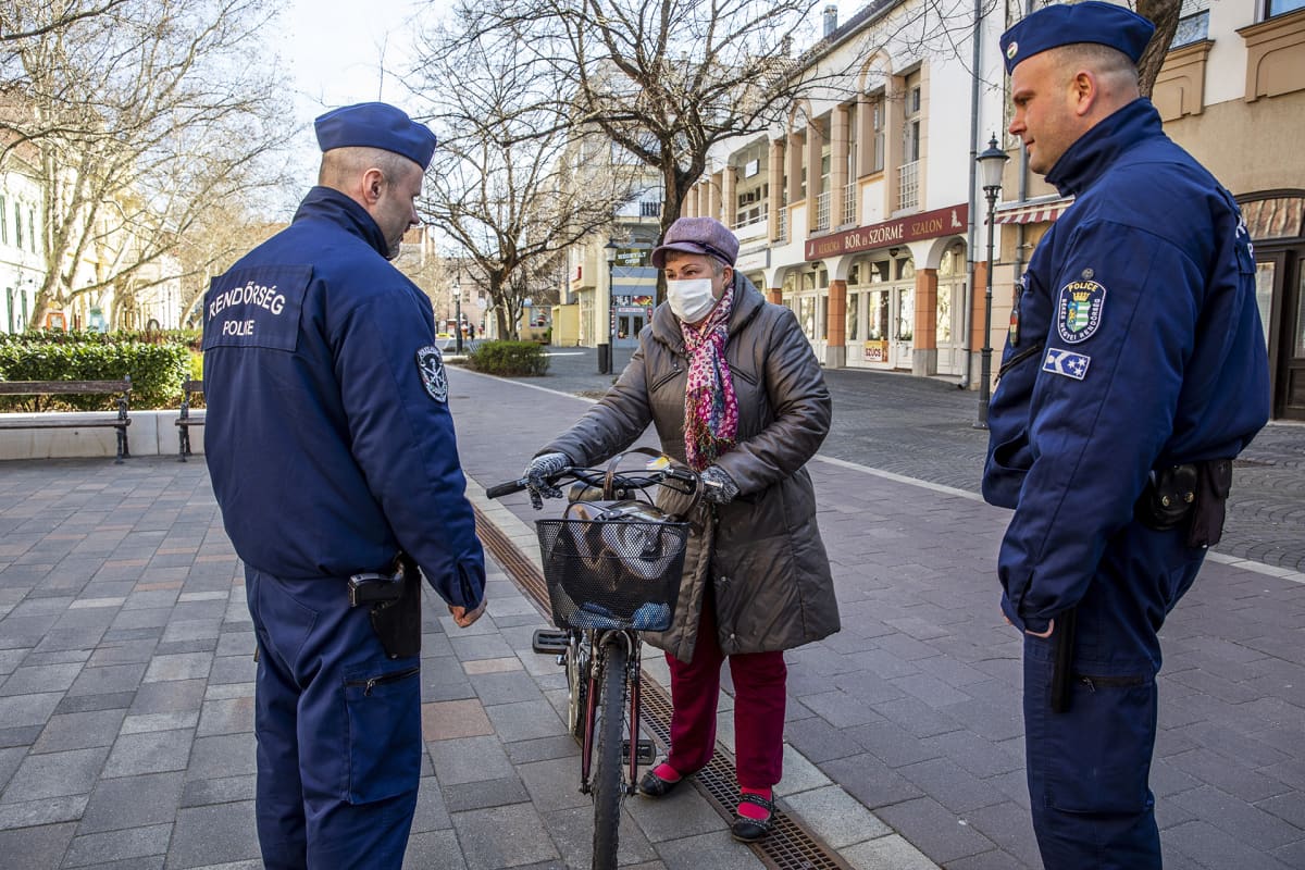 Poliisit keskutelivat polkupyörällä liikkeellä ollen naisen kanssa muuten autiolla kadulla Bekescsabasas Unkarissa.