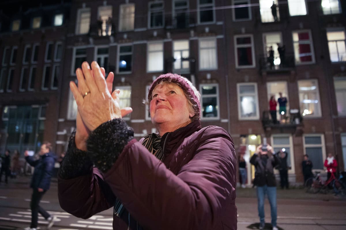 Ihmiset taputtavat terveydenhoitohenkilöstölle Amsterdamissa 17. huhtikuuta.