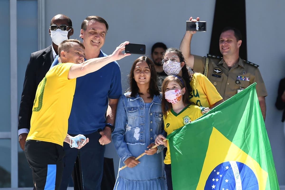 Jair Bolsonaro poseerasi selfiessä kannattajiensa kanssa Planalto-palatsin edustalla Brasiliassa sunnuntaina.