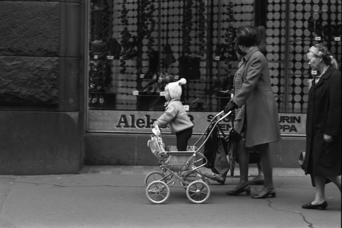 Aleksanterinkatu 13. Rattaissa seisovaa lasta työntävä nainen Aleksanterinkadulla kävelykatukokeilun aikaan vuonna 1970.