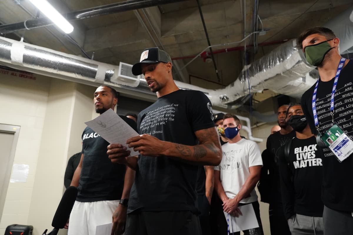 George Hill of the Milwaukee Bucks reads a statement to the media