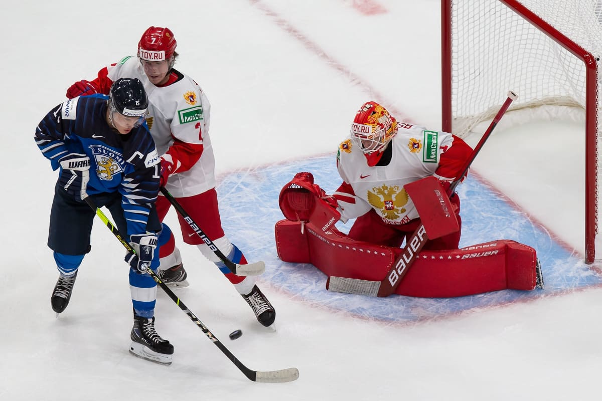 Venäjän Roman Bychkov yrittää pitää Anton Lundellia maalivahti Jaroslav Askarovin edessä.