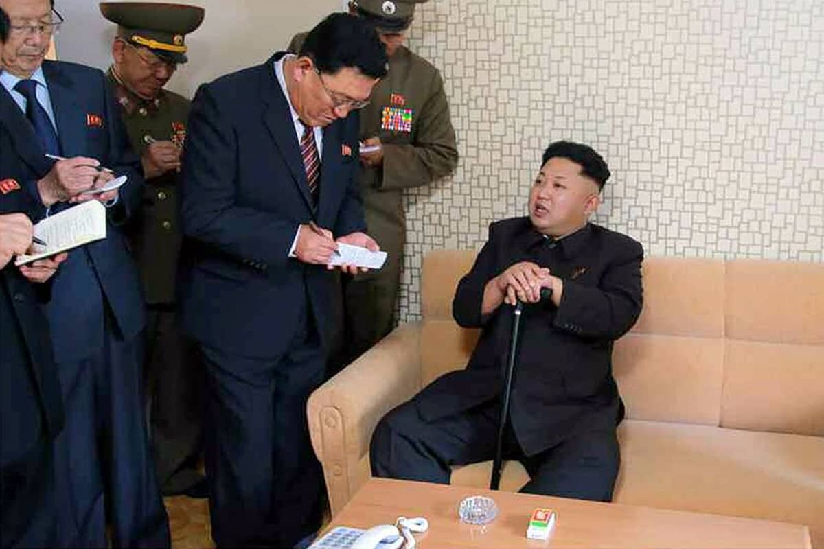 Kim Jong-un istuu sohvalla kävelykepin kanssa, seurue kirjoittaa lehtiöihinsä