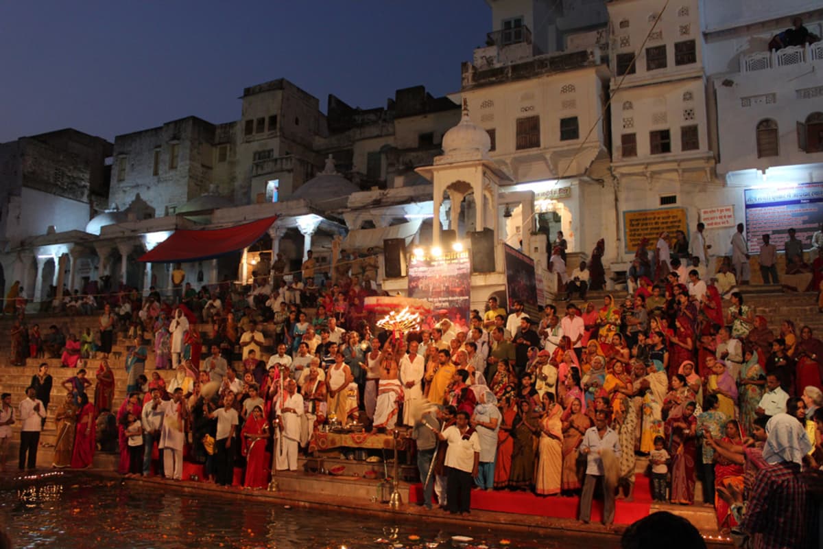 Lannevaatteeseen pukeutunut hindupappi johtaa Maha Aarti –tulirituaalia Pushkarin kylpyportailla.