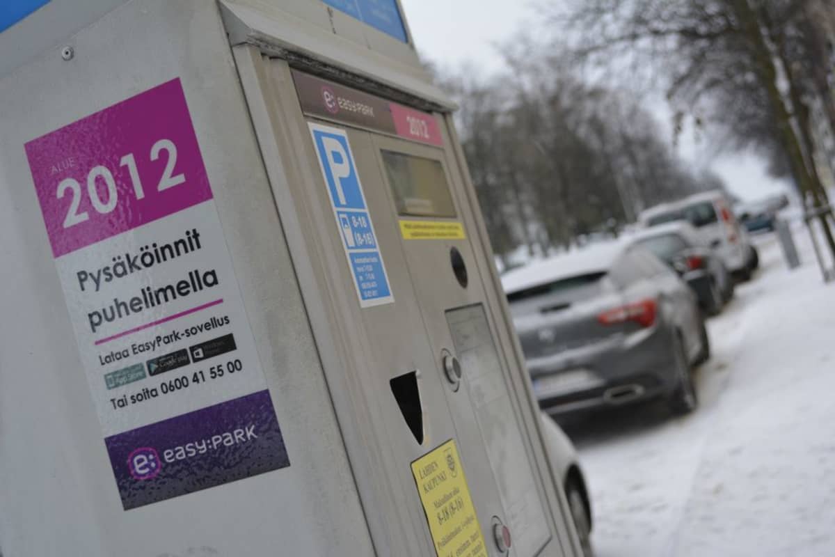 Pysäköintimittari ja autoja parkissa.