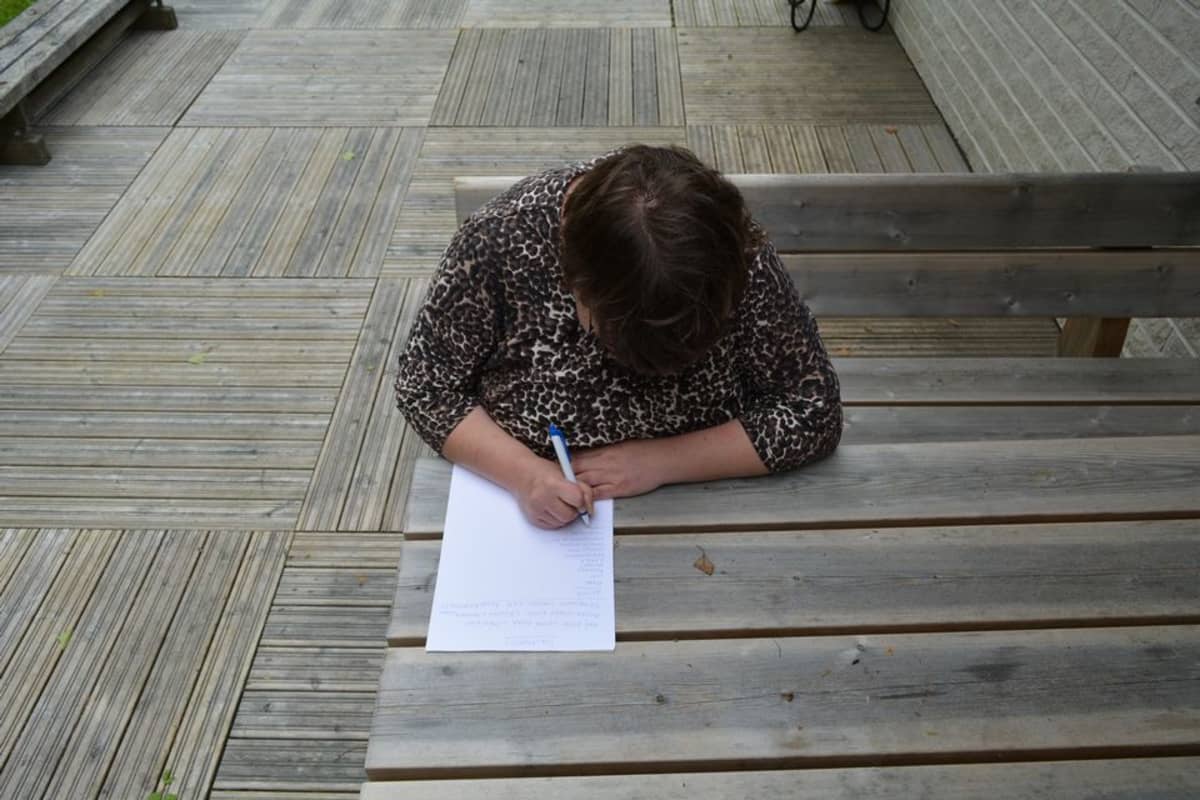 Miia Korhonen listaa paperille haaveitaan tulevaisuuden omaan kotiin hankittavista asioista.