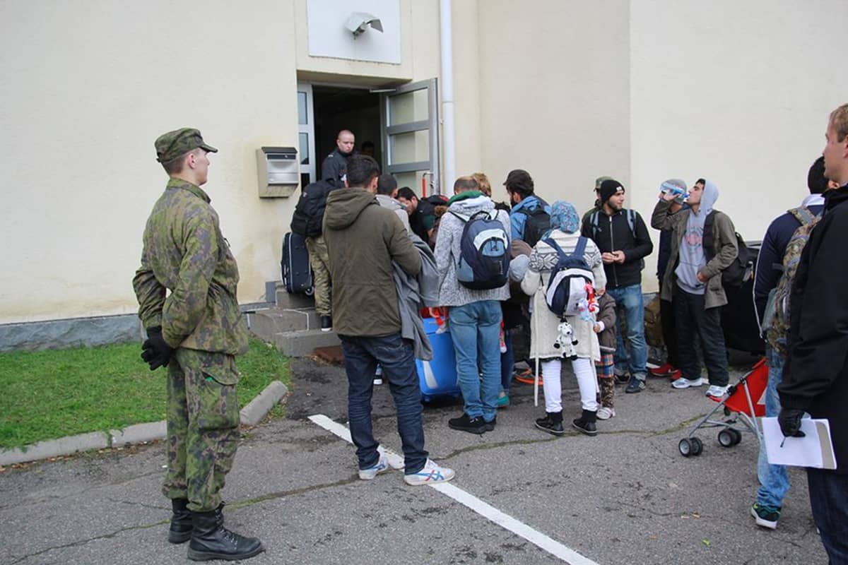 Pihanvalvoja seuraa turvapaikanhakijoiden rekisteröitymistä Tornion järjestelykeskuskessa.