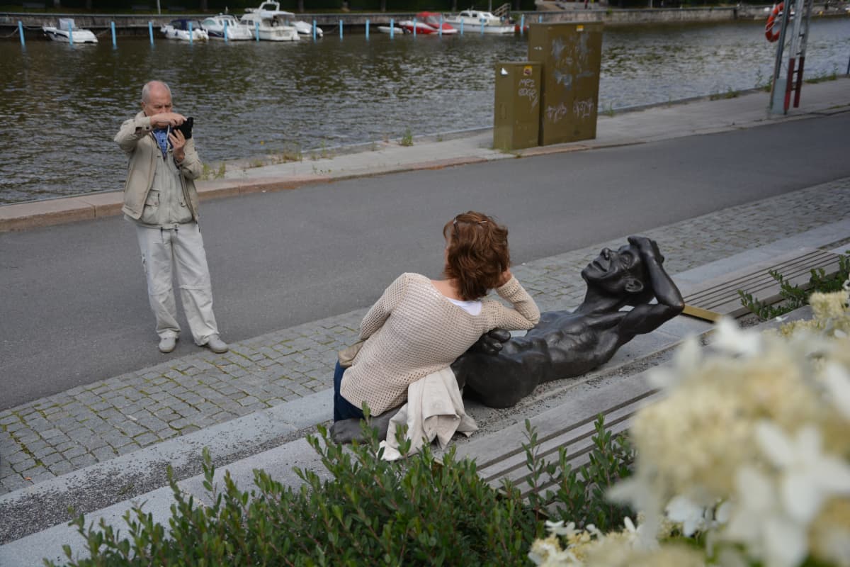 Tähtiin tähyävät -teoksen veistos ja turisteja Turun jokirannassa