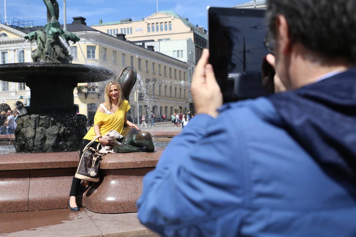 Turisteja Havis Amandan patsaan luona Helsingissä.