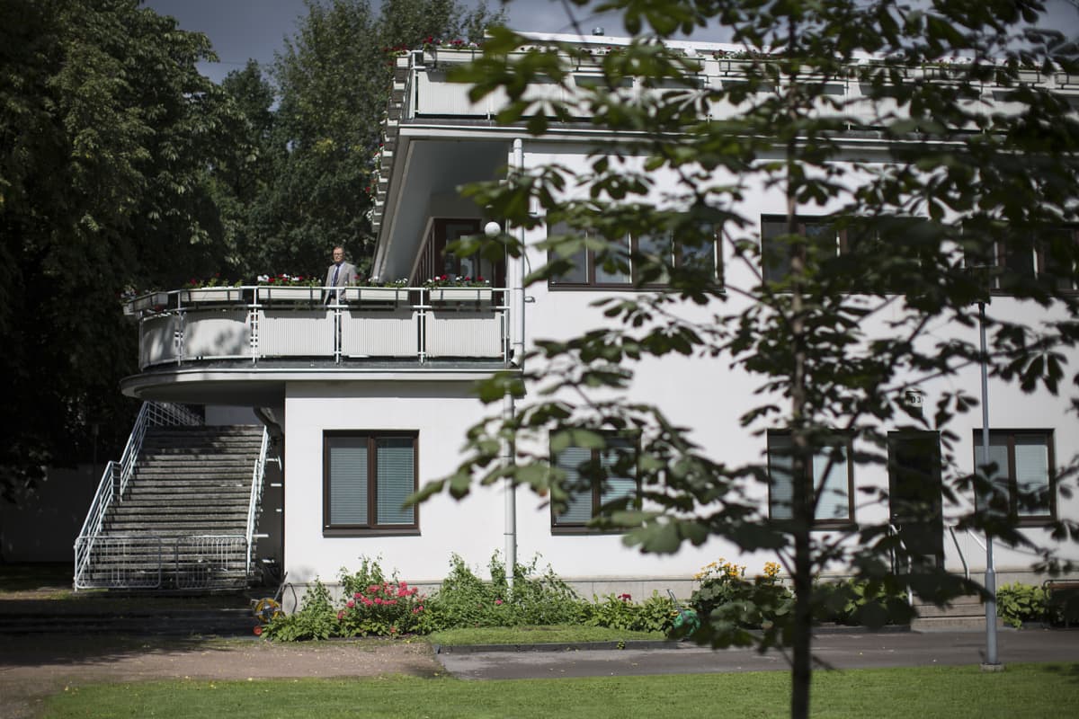 Mies talon parvekkeella.