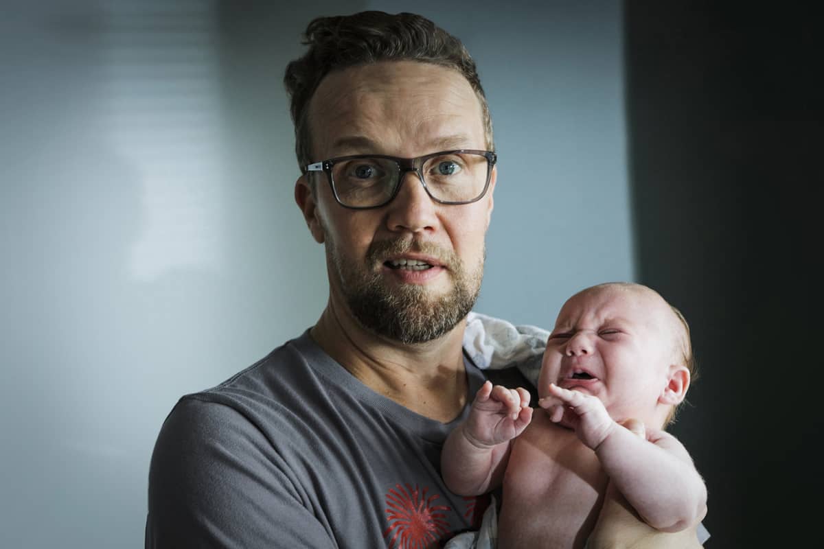Mies pitää lasta sylissään.