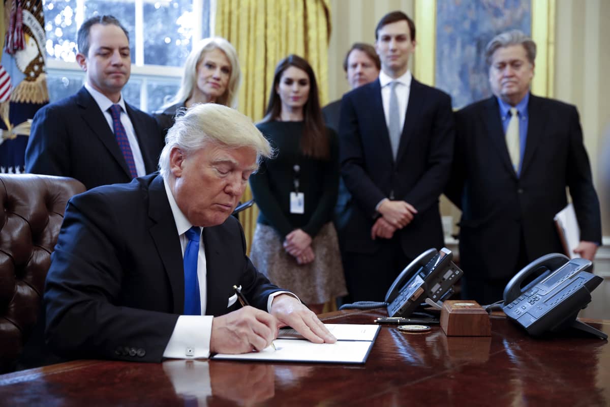 Donald Trump kuvattuna taustajoukkoineen Valkoisessa talossa 24. tammikuuta 2017.