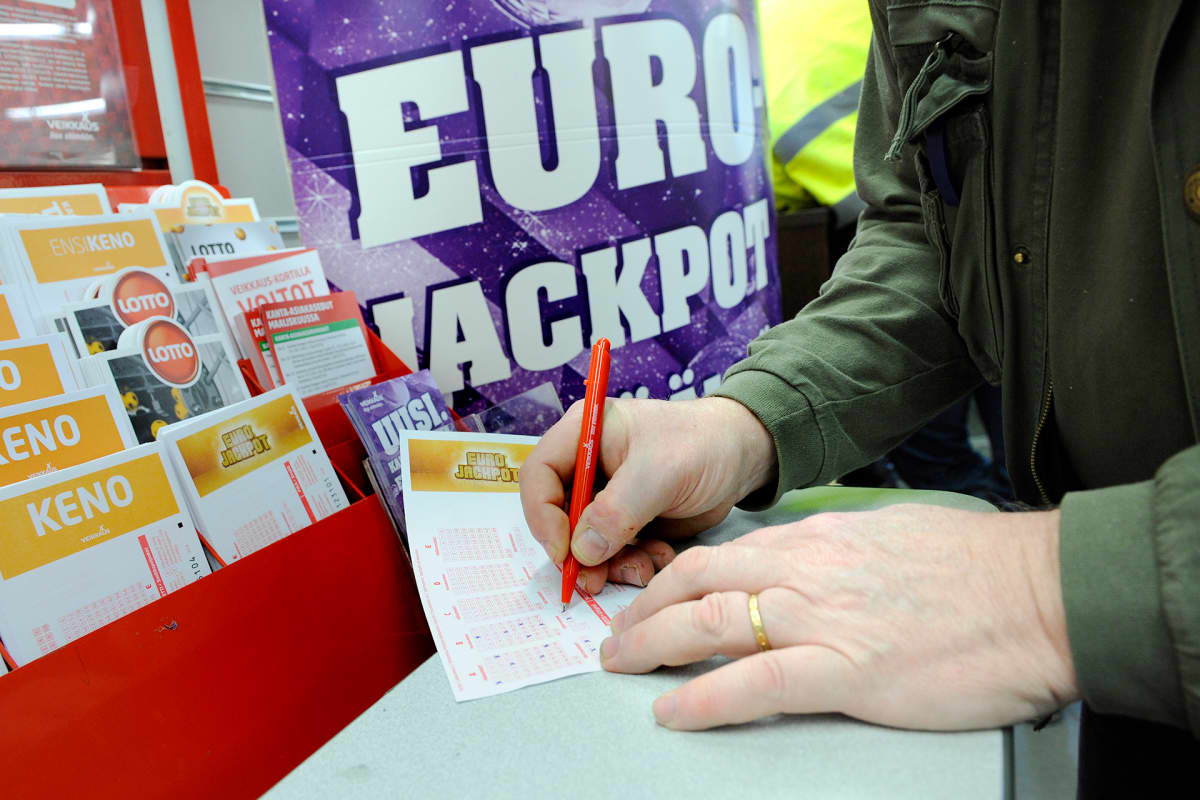 Mies täyttää Eurojackpot-kuponkia.