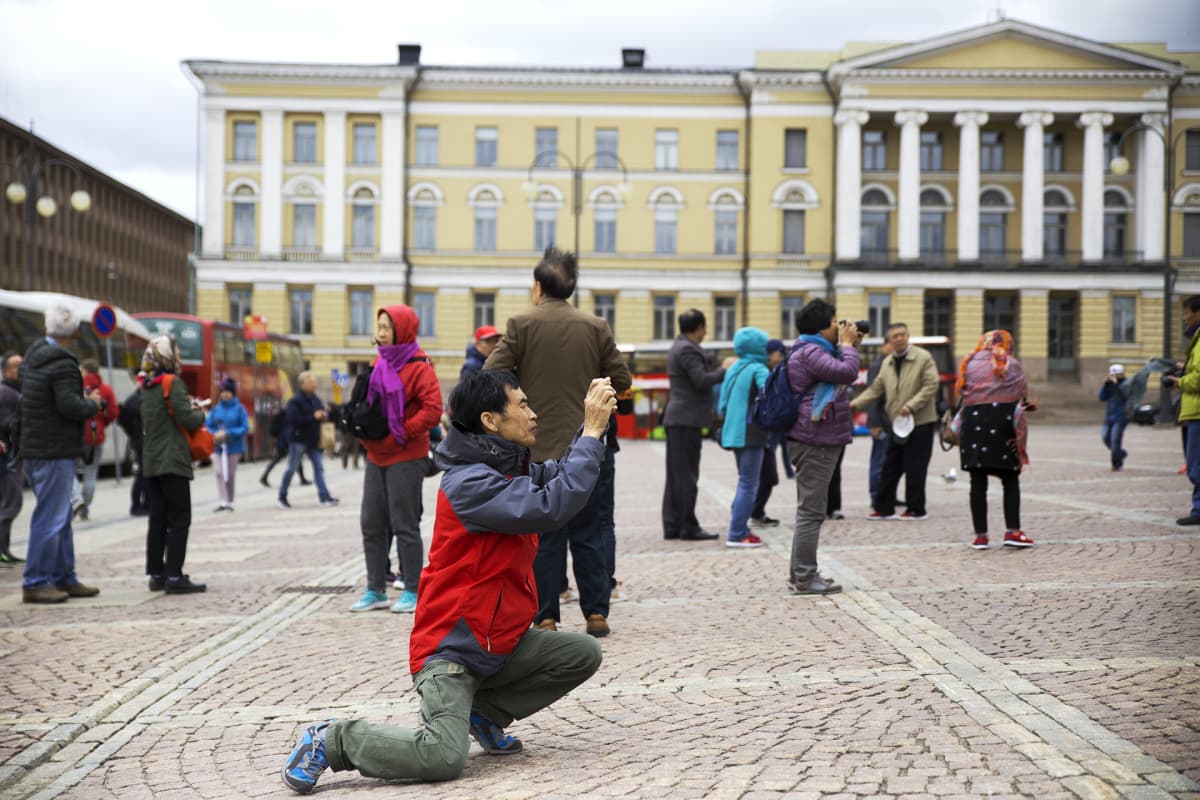Kiinalainen turisti kuvaamassa senaatintorilla