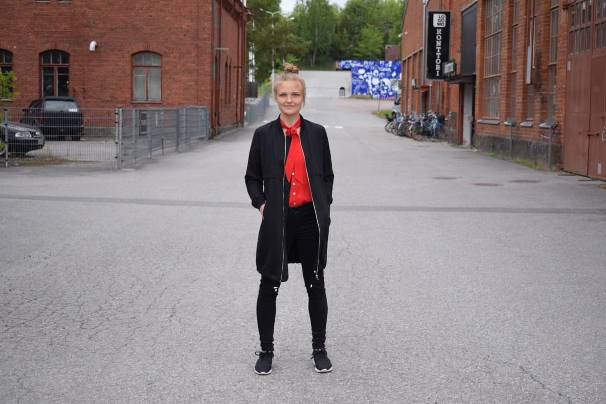 nuori nainen seisoo keskellä pihaa