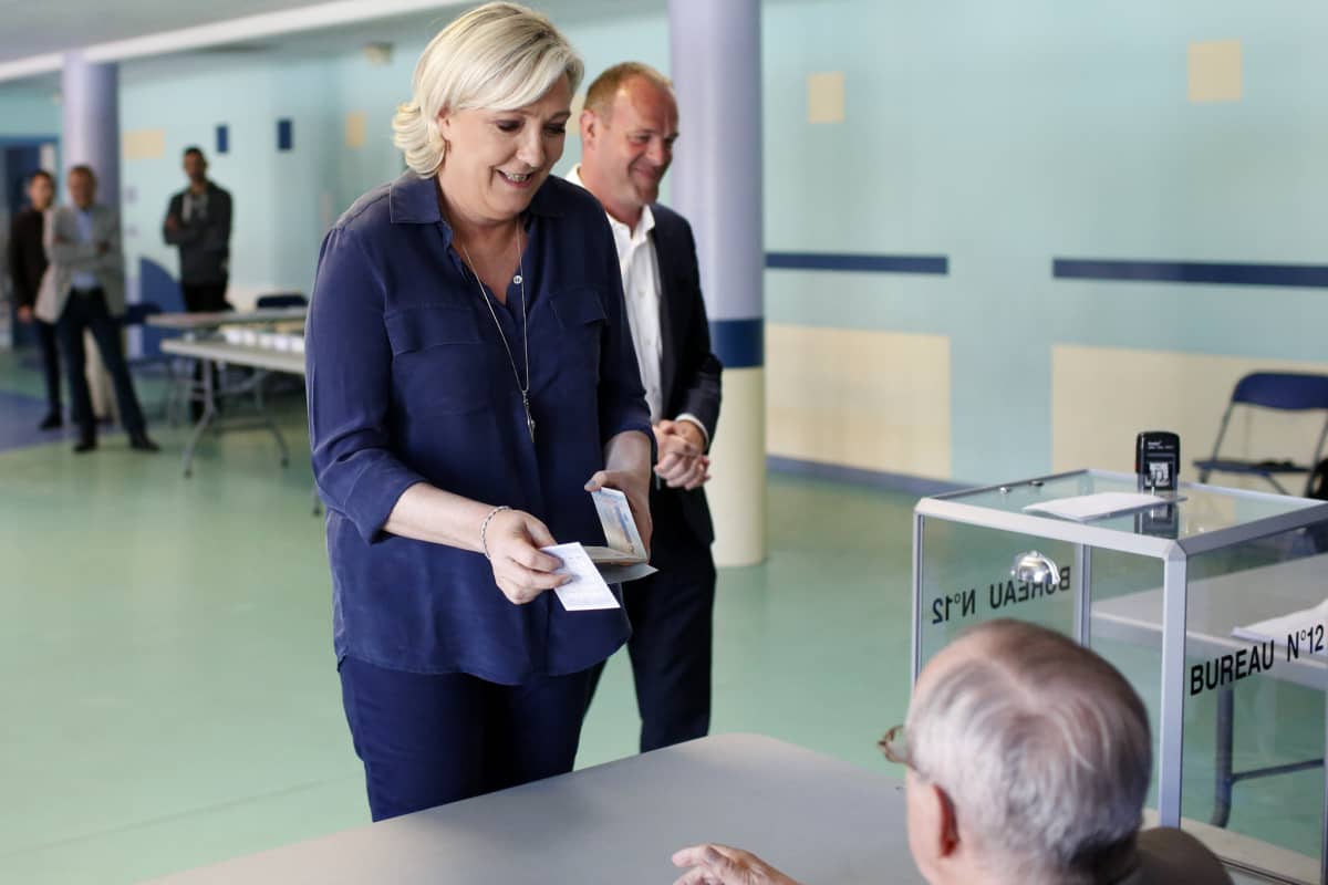 Marine Le Pen ojentaa äänestyslippua.