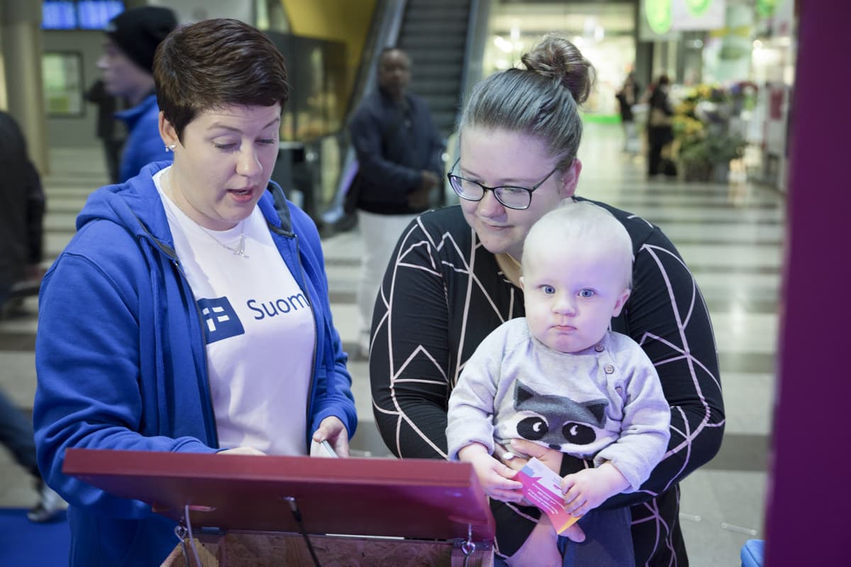 Kansalaisneuvonnan palveluneuvoja Jenni Tauriainen esittelee Suomi.fi -sivustoa porvoolaiselle Reetta Uusalolle ja hänen Manu-pojalleen.