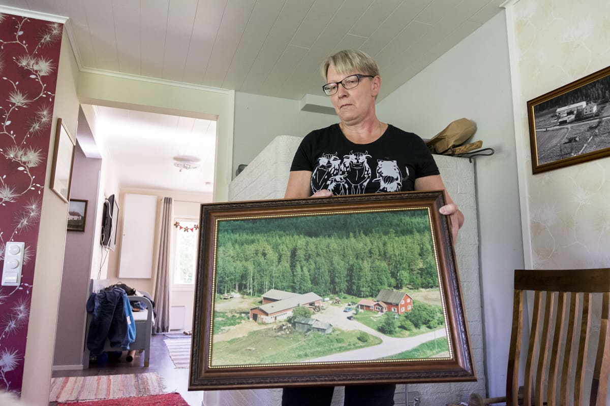 Eija Komulainen pitää käsissään taulua.