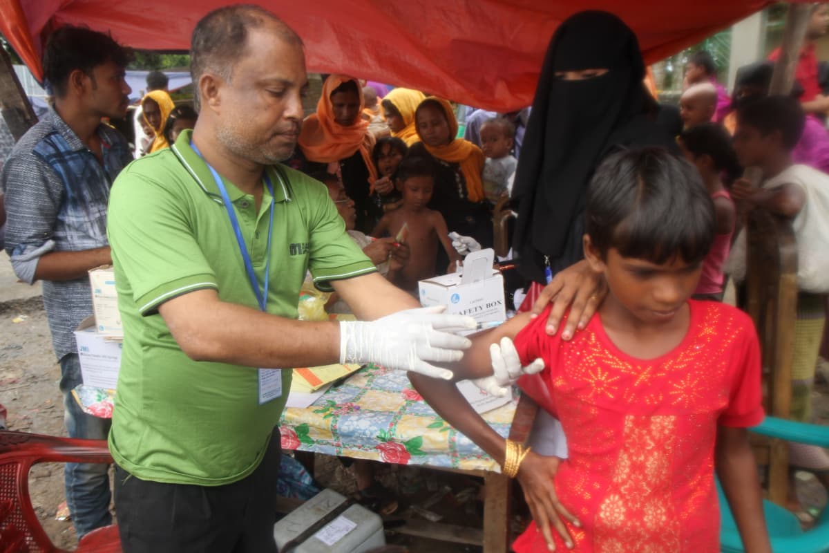 YK:n pakolaisjärjestö UNICEF jakaa Bangladeshiin saapuville pakolaislapsille perusrokotuksia.