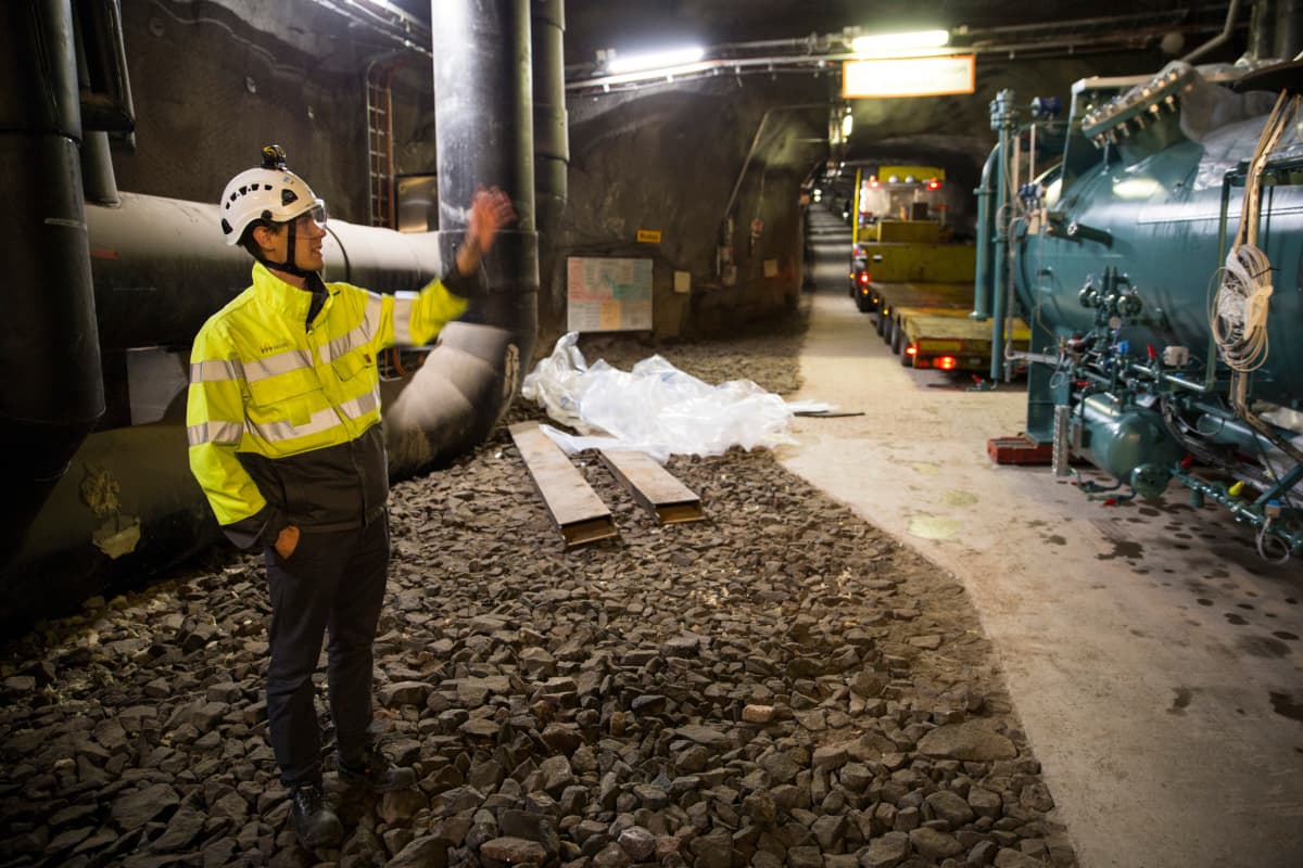 Eero Kaartokallio esittelee lämpöpumpun höyrystinosaa tunnelissa.