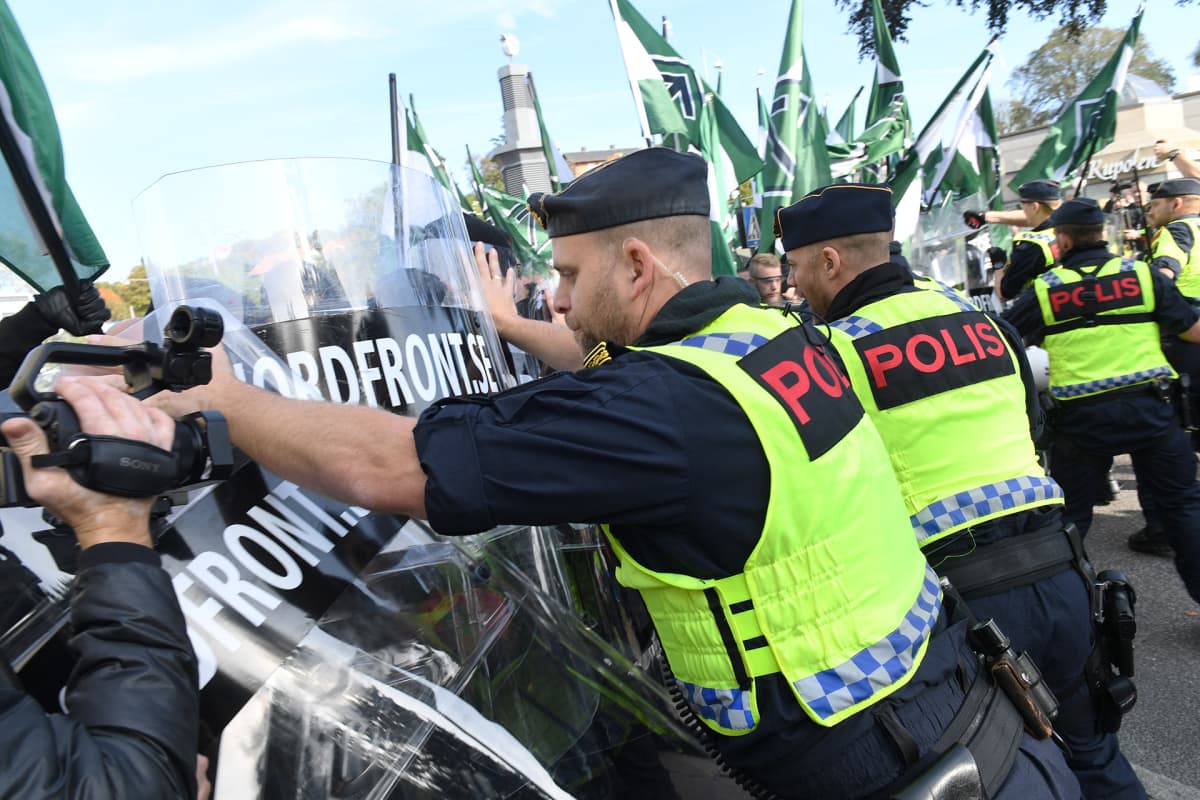 Poliisi estää mielenosoittajia marssimasta kielletylle kaduille.